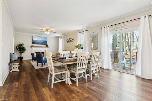 dining room with dark wood-type flooring, ornamental molding, and ceiling fan