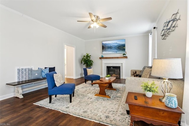 living room with crown molding, dark hardwood / wood-style floors, and ceiling fan