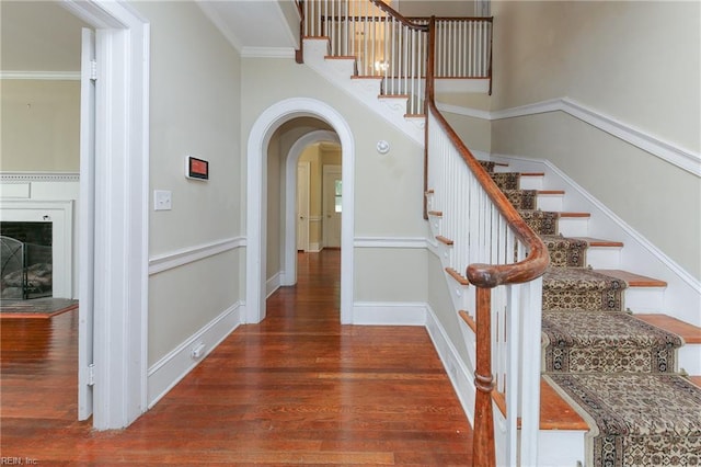 stairs featuring wood-type flooring and ornamental molding