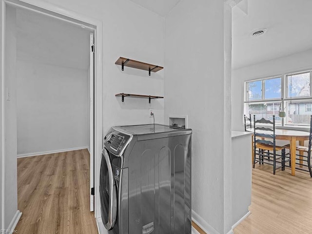 clothes washing area featuring washer hookup and light hardwood / wood-style flooring