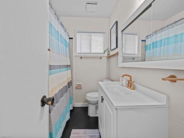 bathroom featuring walk in shower, vanity, and toilet