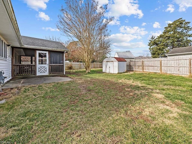 view of yard featuring a storage unit, a patio area, and a sunroom