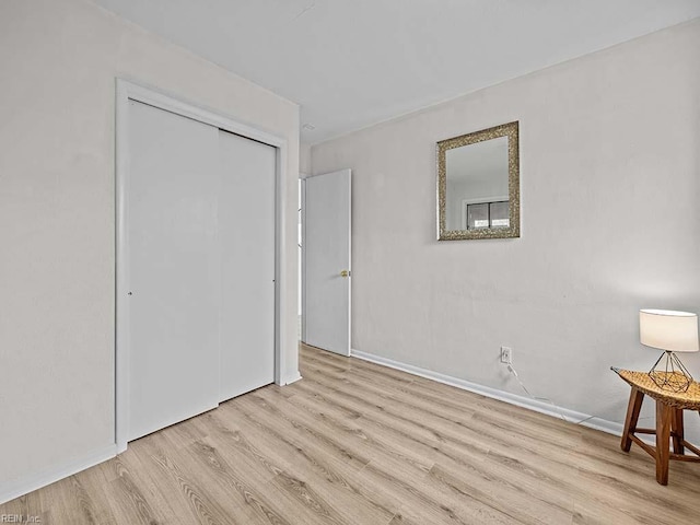 unfurnished bedroom with a closet and light wood-type flooring