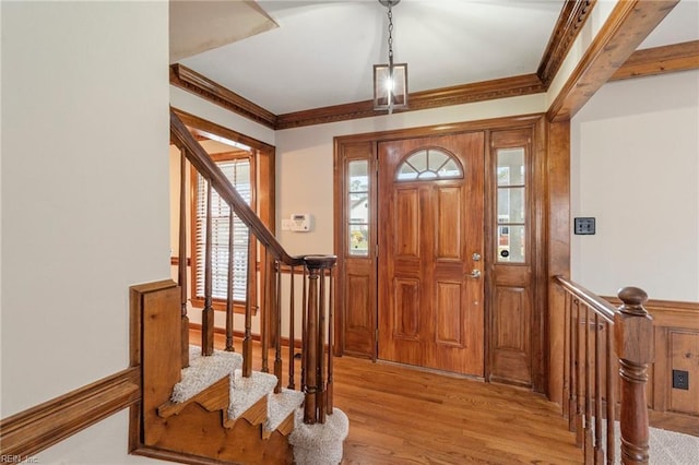 entryway with crown molding and light hardwood / wood-style flooring