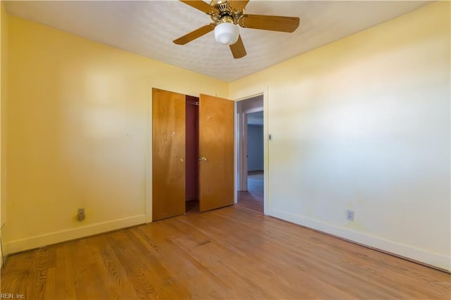 unfurnished bedroom with ceiling fan, a closet, and light hardwood / wood-style flooring