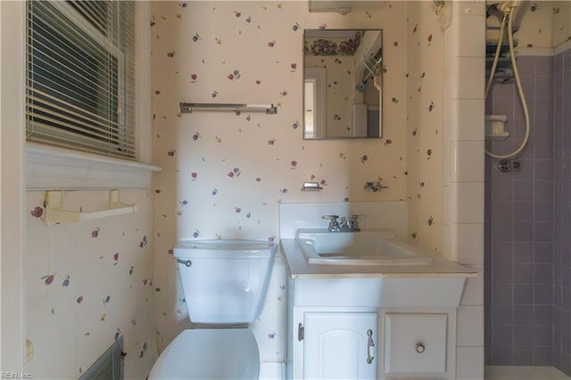 bathroom with vanity, a tile shower, and toilet