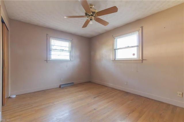 unfurnished room with light hardwood / wood-style flooring, plenty of natural light, and a textured ceiling