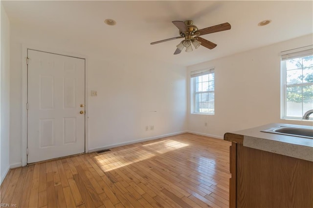 interior space with sink, light hardwood / wood-style flooring, and ceiling fan