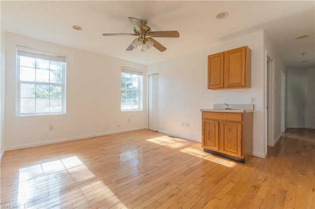 interior space with sink, light hardwood / wood-style floors, and ceiling fan