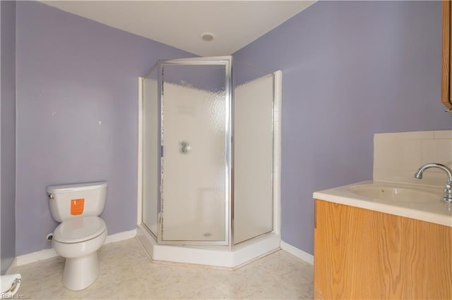 bathroom featuring vanity, a shower with shower door, and toilet