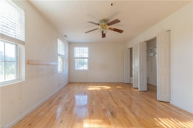 spare room with ceiling fan, light hardwood / wood-style floors, and a wealth of natural light