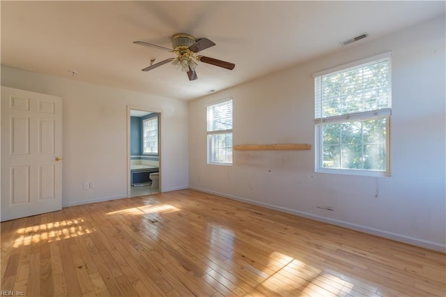 interior space featuring ceiling fan, ensuite bath, and light hardwood / wood-style flooring