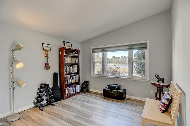 sitting room with vaulted ceiling, baseboards, and wood finished floors