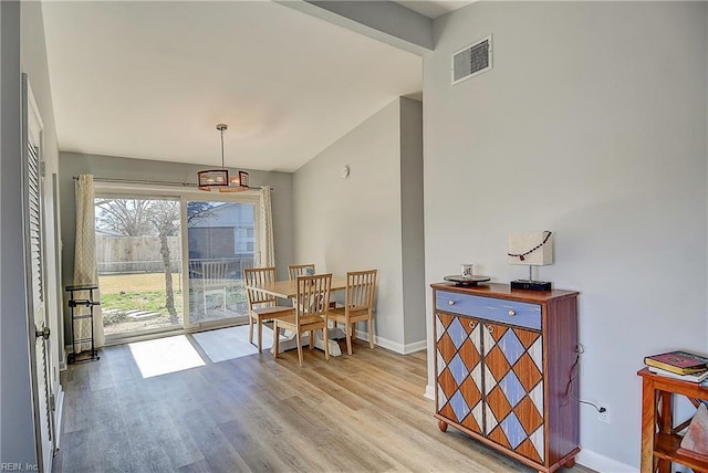 dining area featuring baseboards, visible vents, and wood finished floors