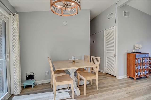 dining space with light wood-type flooring, baseboards, visible vents, and a notable chandelier