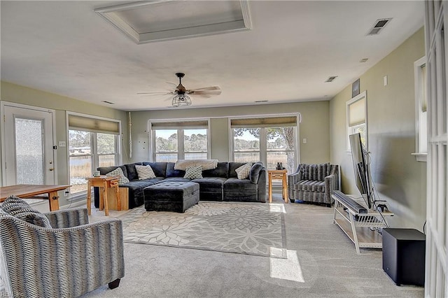 living area with a healthy amount of sunlight, light carpet, and visible vents