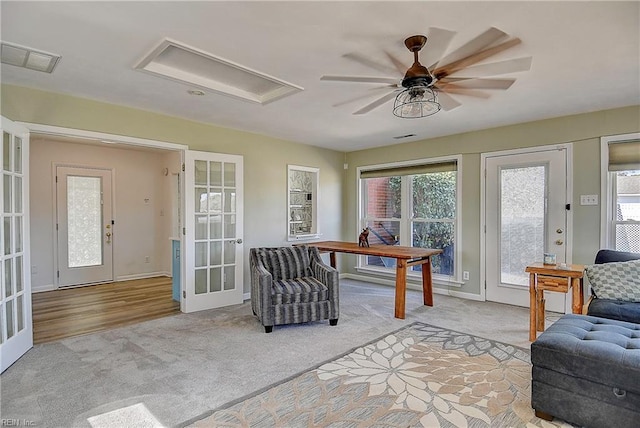 interior space featuring light carpet, baseboards, visible vents, a ceiling fan, and french doors