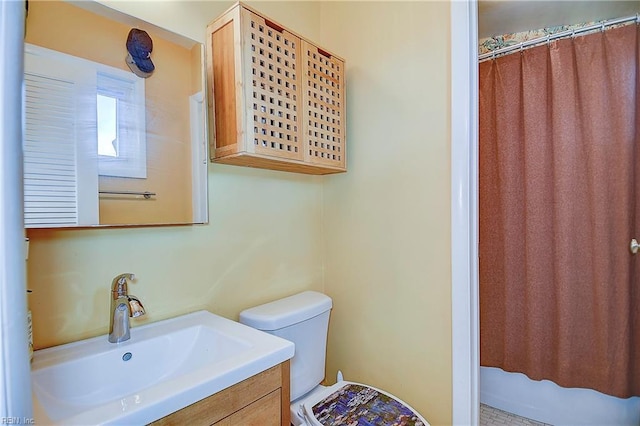 bathroom featuring curtained shower, vanity, and toilet