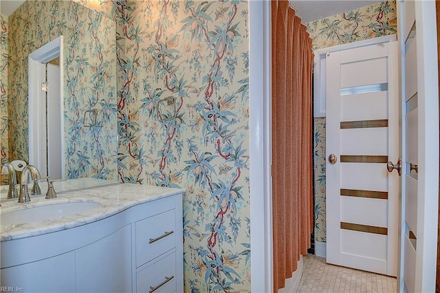 bathroom with tile patterned flooring, vanity, and wallpapered walls