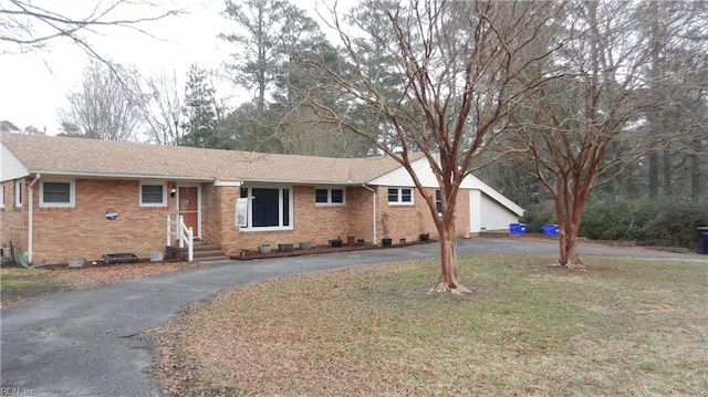 ranch-style house with brick siding, crawl space, a front yard, and aphalt driveway