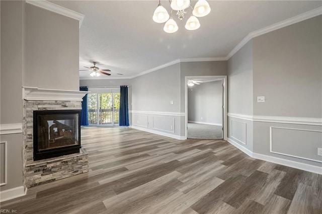 unfurnished living room with a stone fireplace, ceiling fan with notable chandelier, ornamental molding, and hardwood / wood-style flooring