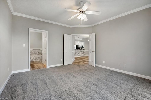 unfurnished bedroom featuring carpet floors, ornamental molding, ceiling fan, and ensuite bathroom