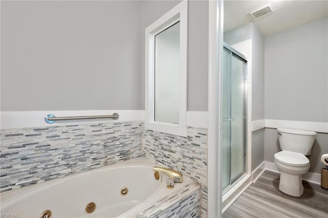 bathroom featuring hardwood / wood-style flooring, plus walk in shower, and toilet