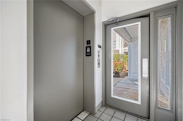 entryway featuring light tile patterned flooring and elevator