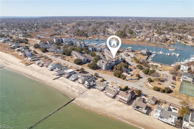 birds eye view of property with a water view and a beach view