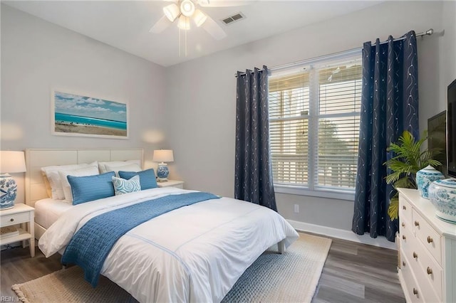 bedroom with multiple windows, dark wood-type flooring, and ceiling fan