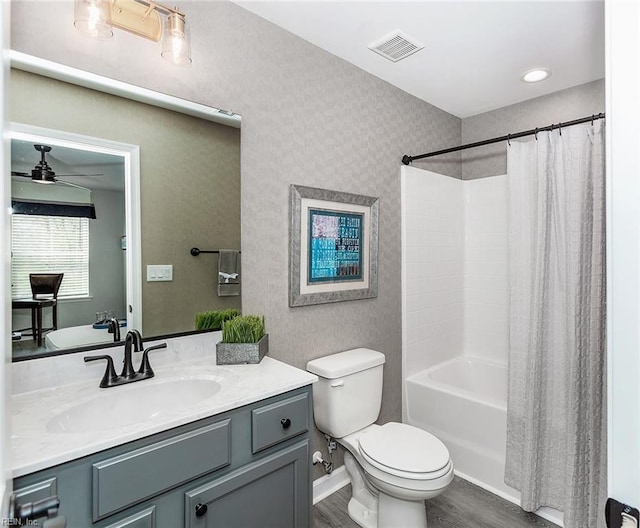 full bathroom featuring shower / tub combo with curtain, ceiling fan, hardwood / wood-style floors, vanity, and toilet