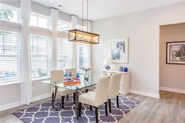 dining area featuring plenty of natural light, light hardwood / wood-style floors, and a notable chandelier