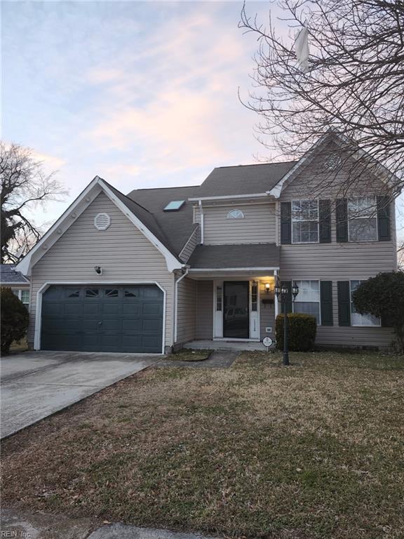 view of front of home with a yard and a garage