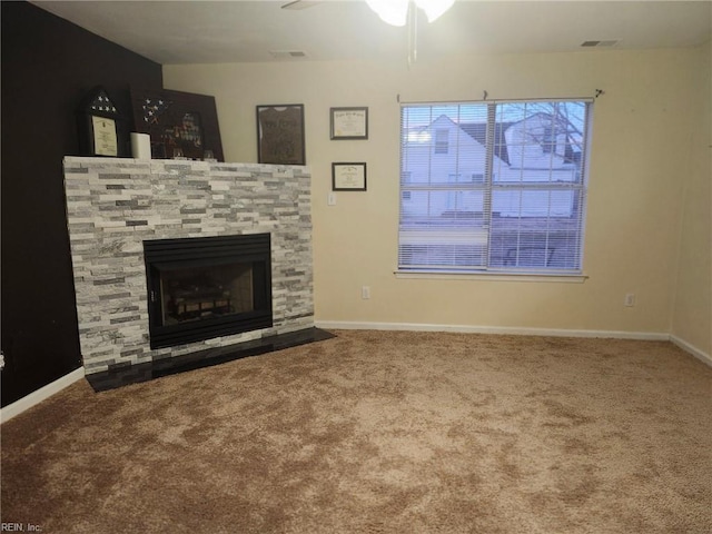 unfurnished living room with ceiling fan, a fireplace, and carpet floors