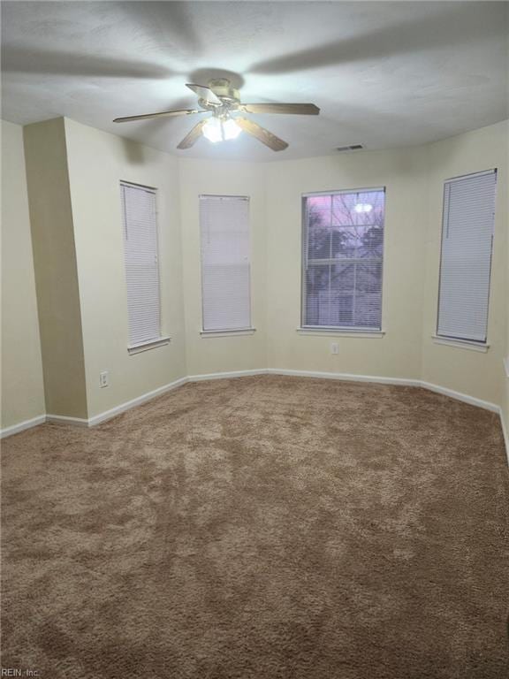 carpeted spare room featuring ceiling fan