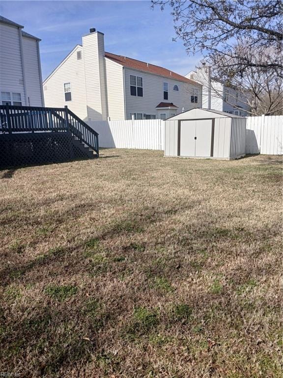 view of yard featuring a storage unit and a wooden deck