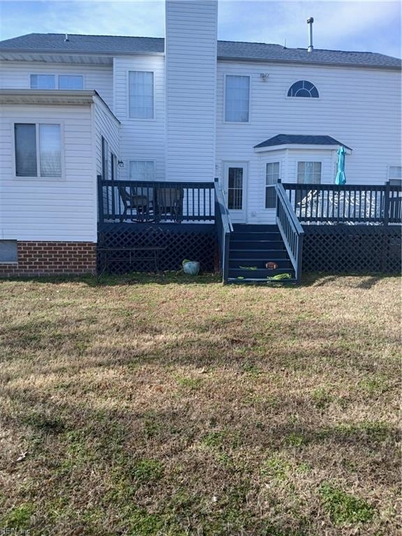 back of house featuring a deck and a lawn