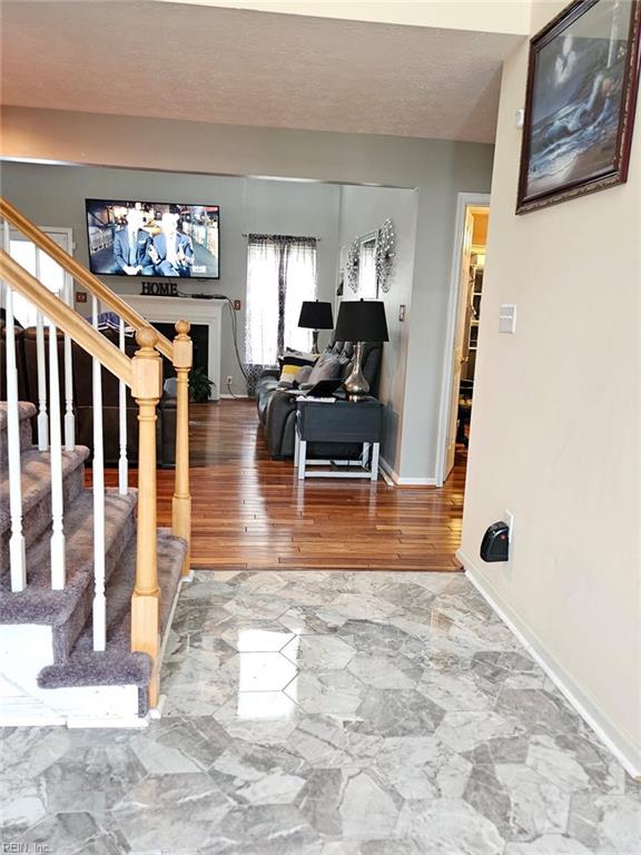 living room with a textured ceiling and wood-type flooring