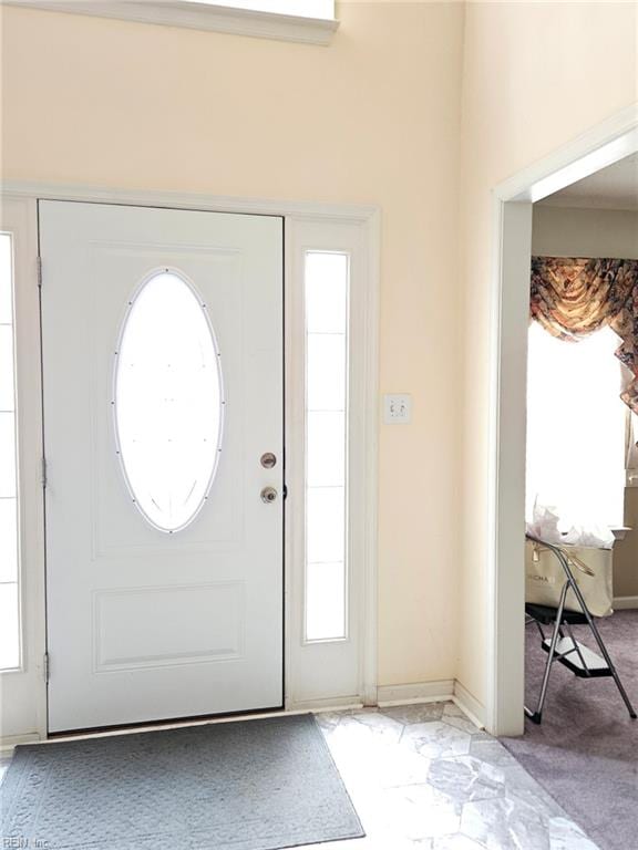 carpeted entrance foyer featuring plenty of natural light