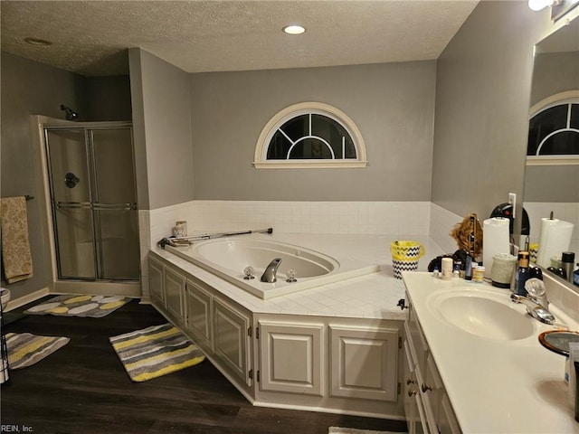 bathroom with hardwood / wood-style flooring, vanity, independent shower and bath, and a textured ceiling