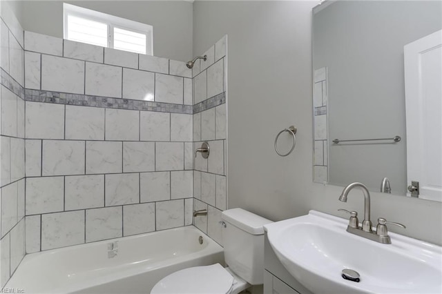 full bathroom featuring tiled shower / bath, sink, and toilet