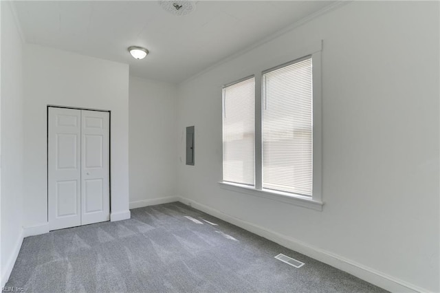 unfurnished bedroom featuring a closet, electric panel, and light carpet