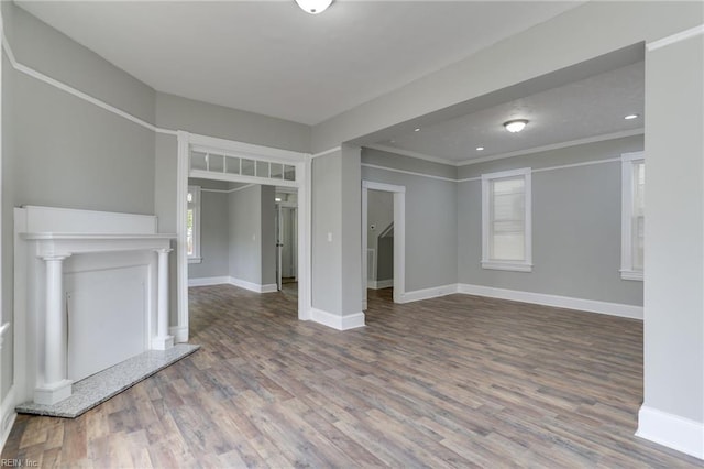 unfurnished living room featuring crown molding and hardwood / wood-style floors