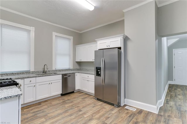 kitchen with light stone countertops, appliances with stainless steel finishes, sink, and white cabinets