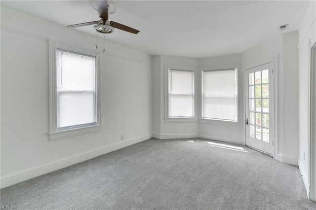 spare room featuring light colored carpet and ceiling fan