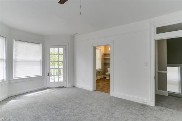 empty room featuring light colored carpet and ceiling fan