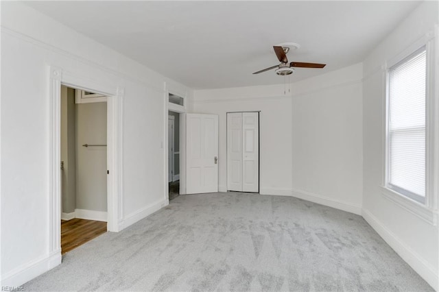 unfurnished bedroom with ceiling fan, light carpet, and multiple windows