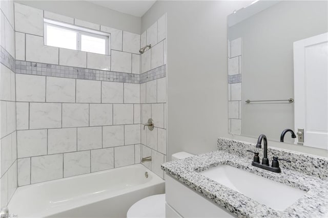 full bathroom with tiled shower / bath, vanity, and toilet