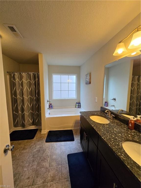 bathroom featuring independent shower and bath, vanity, tile patterned floors, and a textured ceiling