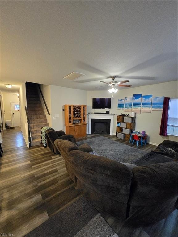 living room with ceiling fan, wood-type flooring, and a textured ceiling